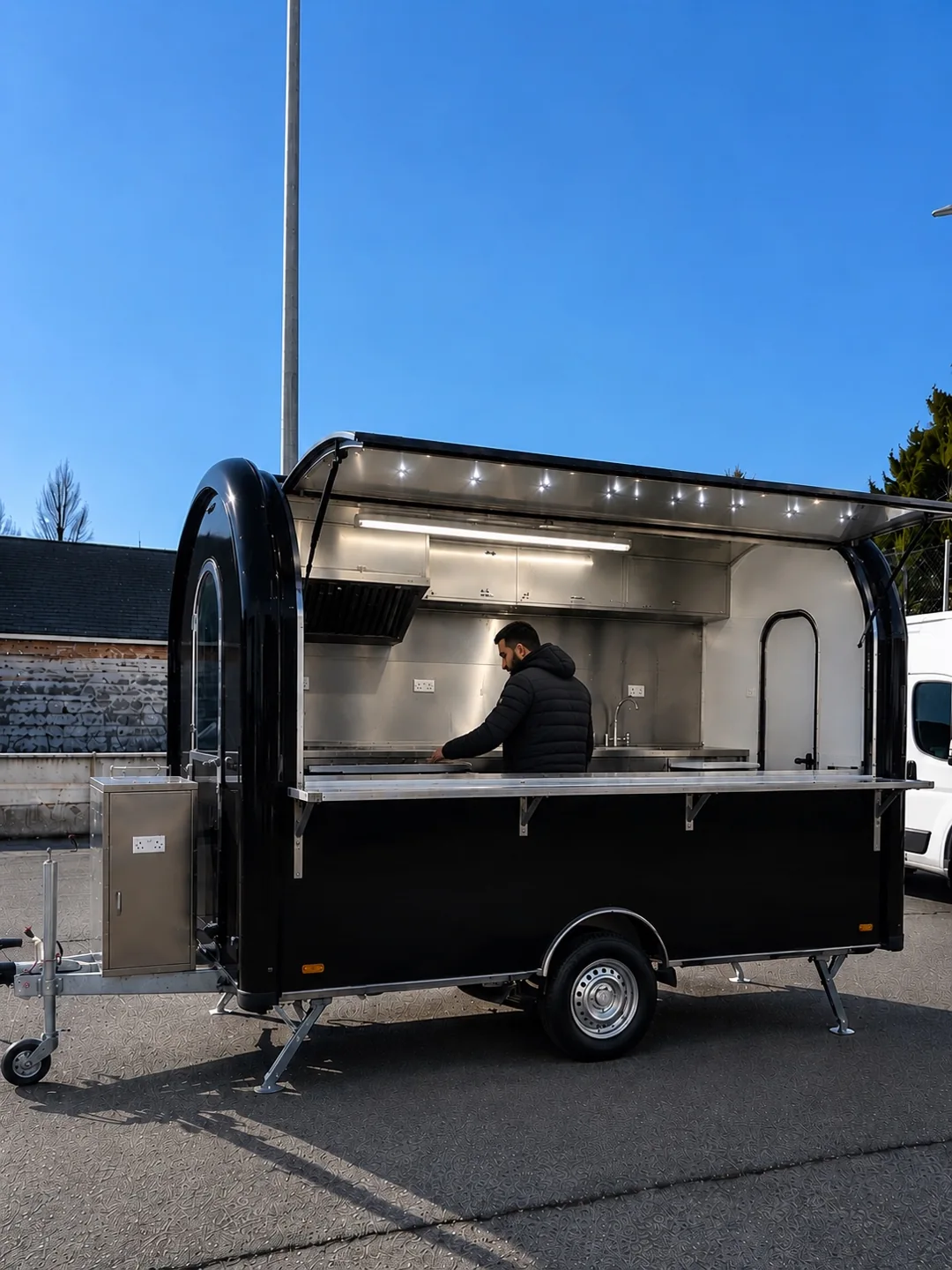 Remorque JAN FACTORY noire avec hayon de vente ouvert, comptoir et éclairage extérieur